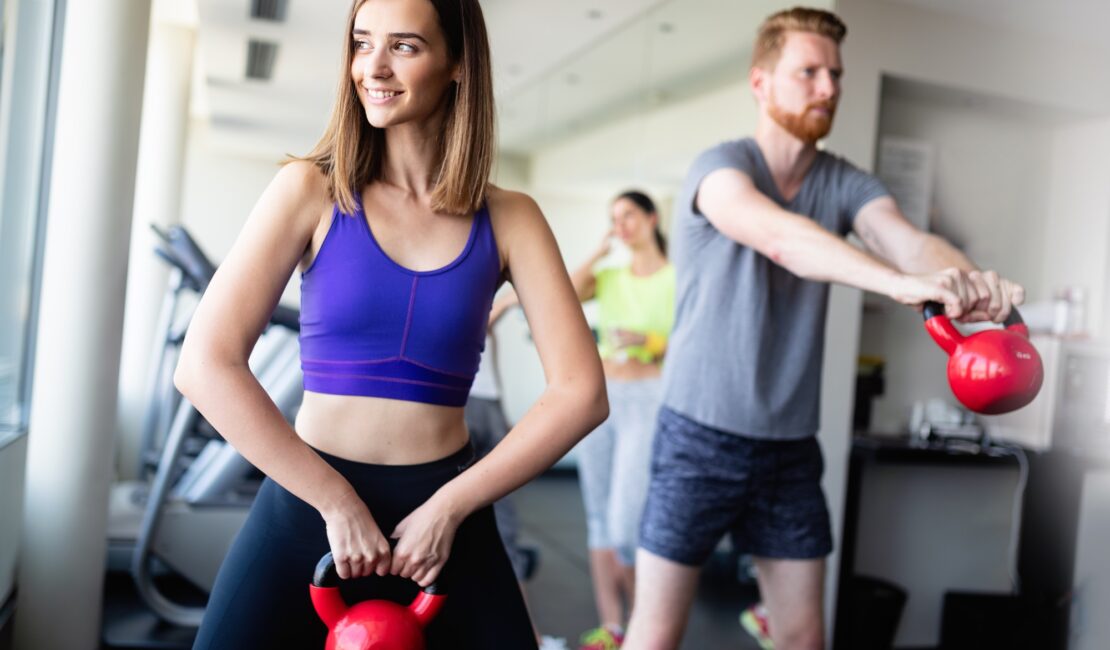 Group having functional fitness training with kettlebell in sport gym