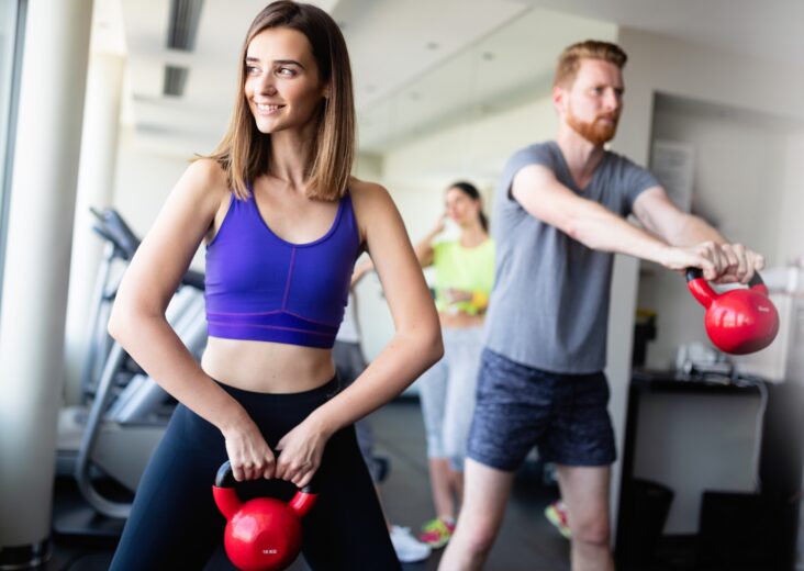 Group having functional fitness training with kettlebell in sport gym