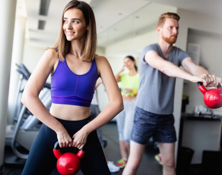 Group having functional fitness training with kettlebell in sport gym