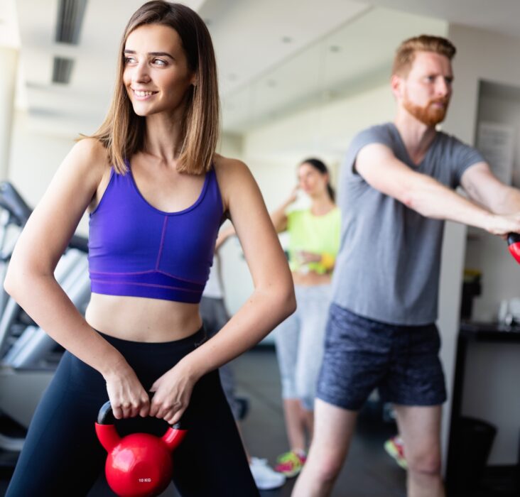 Group having functional fitness training with kettlebell in sport gym