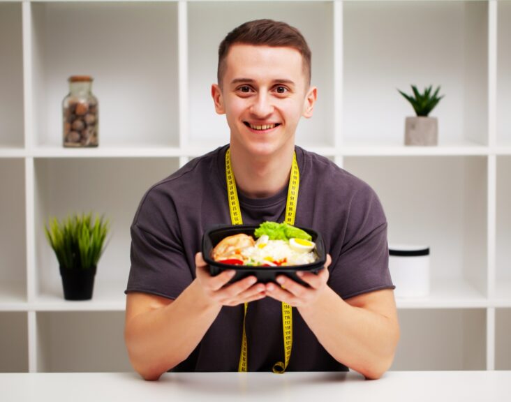Trainer consumes a high-protein meal of meat and fruits.
